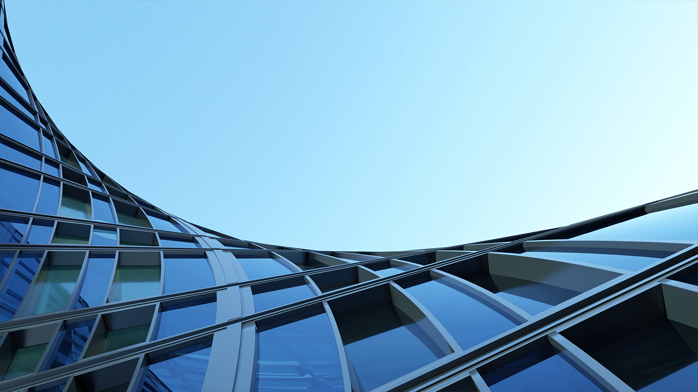 Low-angle view of a curved glass office building, representing the new engineering systems built with Claude Code.